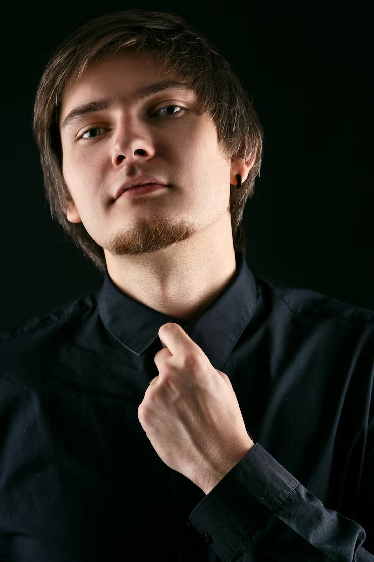 man-with-long-hair-holds-his-hand-collar-black-shirt_8353-1310